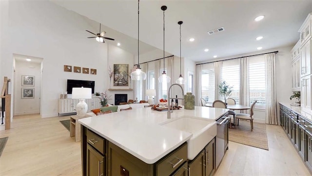 12043 Lake View Blvd, Mont Belvieu, TX 77523 - kitchen featuring light wood-style flooring, a fireplace, ceiling fan, recessed lighting, and a center island with sink