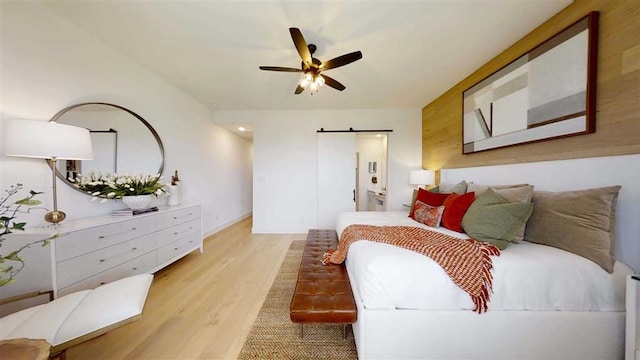 12043 Lake View Blvd, Mont Belvieu, TX 77523 - bedroom with a barn door, light wood finished floors, and ceiling fan