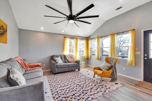 living area featuring wood finished floors, baseboards, visible vents, lofted ceiling, and ceiling fan