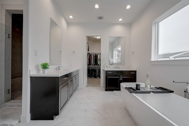 2414 Canal St Unit A, Houston, TX 77003 - full bath featuring marble finish flooring, two vanities, recessed lighting, a freestanding tub, and a spacious closet