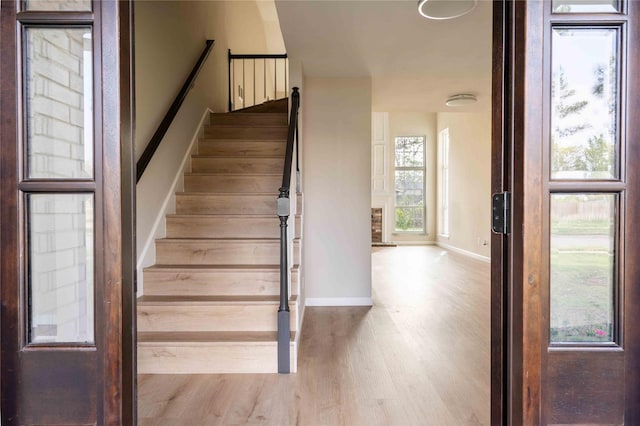 stairway with baseboards and wood finished floors