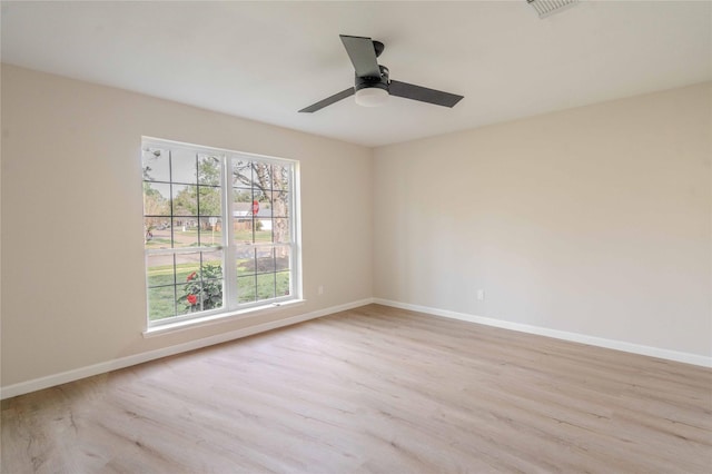 spare room featuring visible vents, ceiling fan, baseboards, and wood finished floors