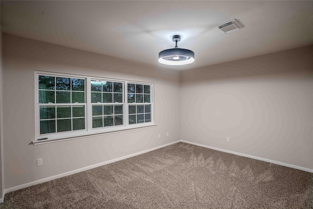 carpeted empty room with visible vents and baseboards