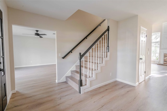 stairs with ceiling fan, baseboards, and wood finished floors