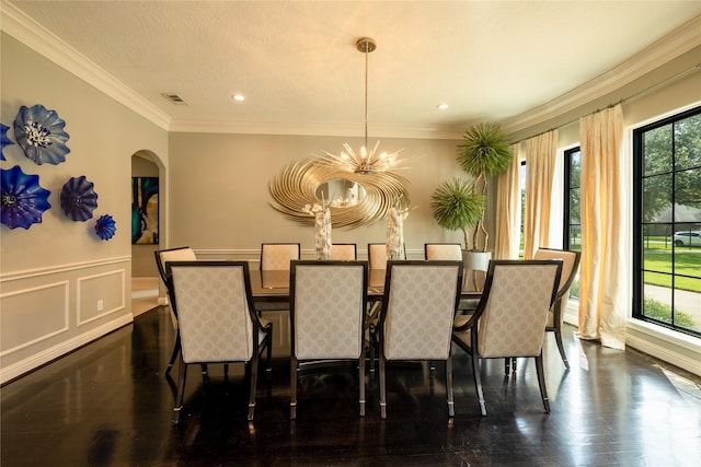 dining room featuring wainscoting, a healthy amount of sunlight, arched walkways, and dark wood-type flooring
