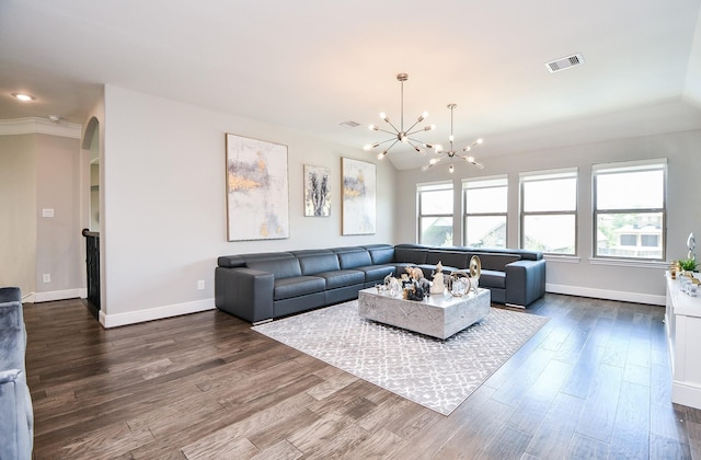 living room featuring visible vents, baseboards, dark wood-style floors, arched walkways, and a notable chandelier