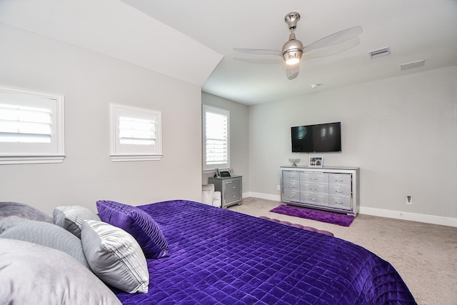 carpeted bedroom with visible vents, a ceiling fan, and baseboards