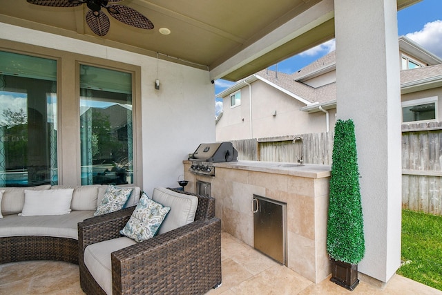 view of patio with area for grilling, an outdoor kitchen, ceiling fan, and fence