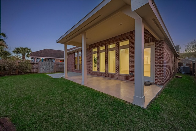 6010 Le Moyne Pass Ln, Missouri City, TX 77459 - back of property with a lawn, central AC, fence, brick siding, and a patio area