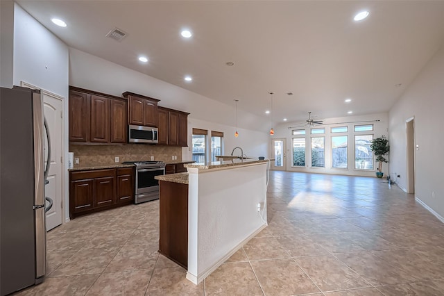 6010 Le Moyne Pass Ln, Missouri City, TX 77459 - kitchen with a center island with sink, tasteful backsplash, recessed lighting, stainless steel appliances, and dark brown cabinets