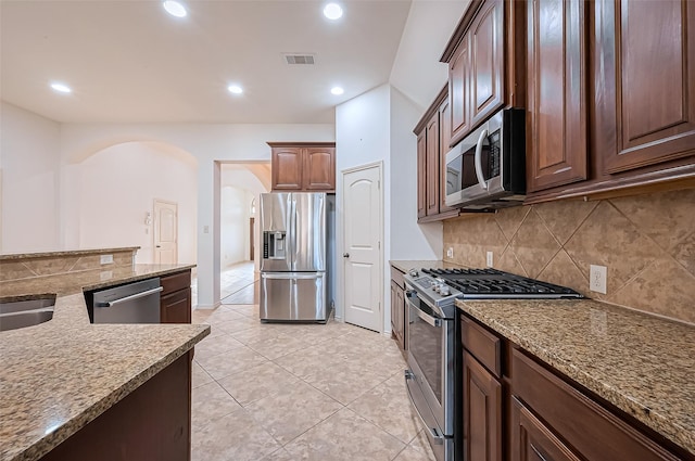 6010 Le Moyne Pass Ln, Missouri City, TX 77459 - kitchen featuring visible vents, recessed lighting, arched walkways, stainless steel appliances, and backsplash