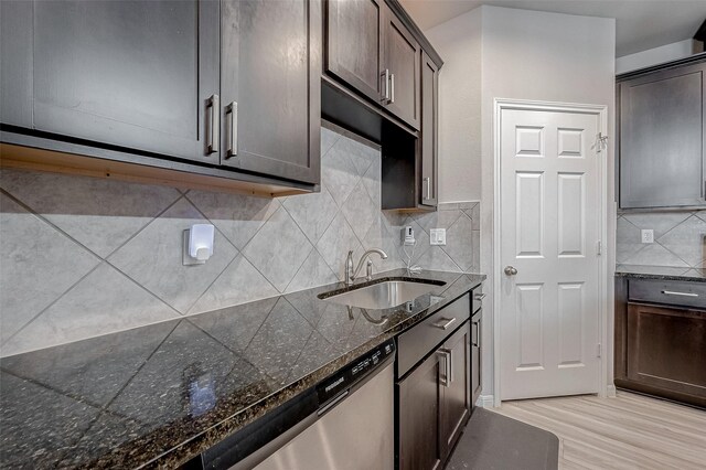 kitchen with stainless steel dishwasher, dark brown cabinetry, tasteful backsplash, and a sink