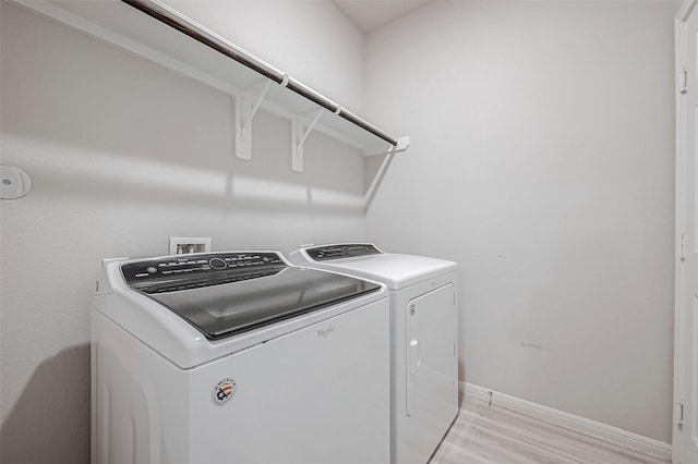 laundry room with washer and clothes dryer, laundry area, light wood finished floors, and baseboards