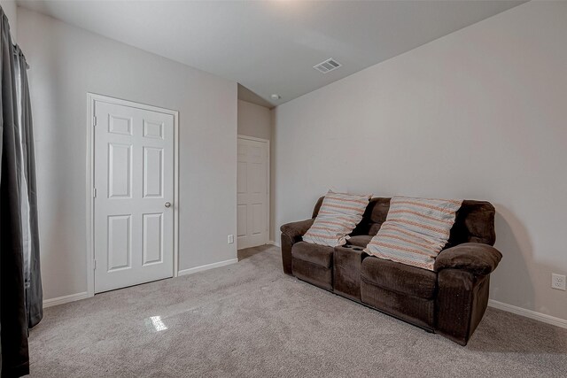 sitting room with visible vents, carpet flooring, baseboards, and lofted ceiling