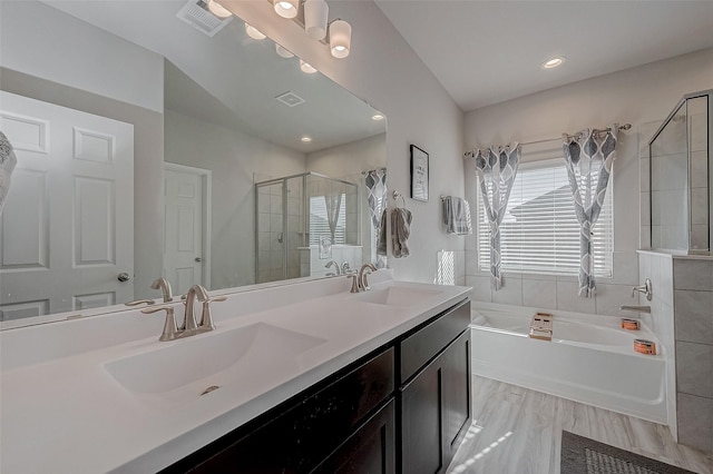 full bathroom with a garden tub, a stall shower, visible vents, and a sink