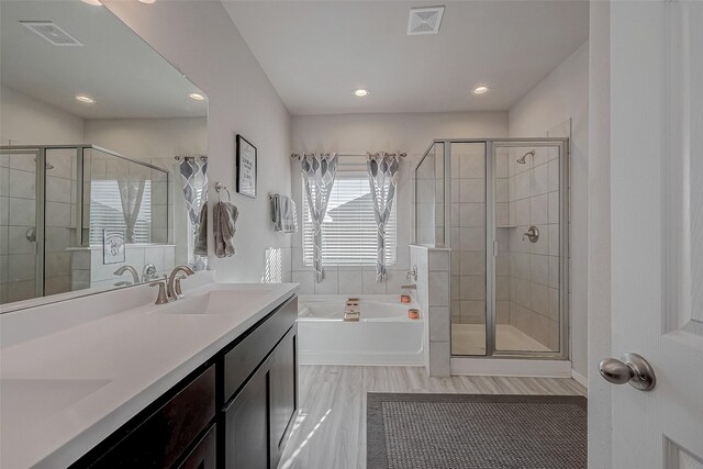 bathroom featuring visible vents, a shower stall, double vanity, a bath, and a sink