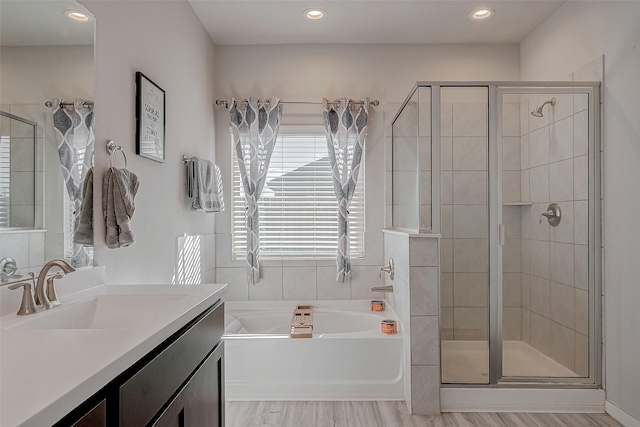 bathroom featuring a bath, recessed lighting, a shower stall, and vanity