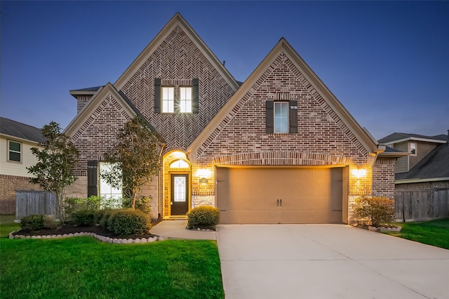 view of front of property featuring brick siding, driveway, a front lawn, and fence