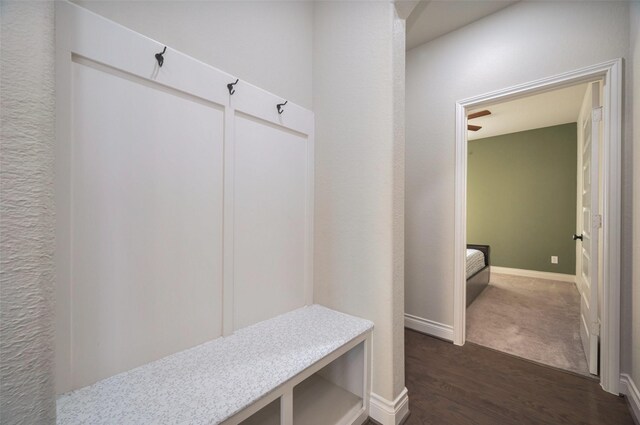 mudroom with dark wood finished floors and baseboards