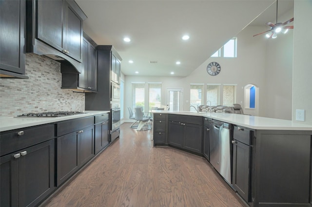 kitchen with wood finished floors, recessed lighting, stainless steel appliances, light countertops, and decorative backsplash
