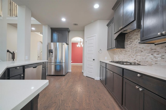 kitchen featuring tasteful backsplash, visible vents, light countertops, appliances with stainless steel finishes, and arched walkways