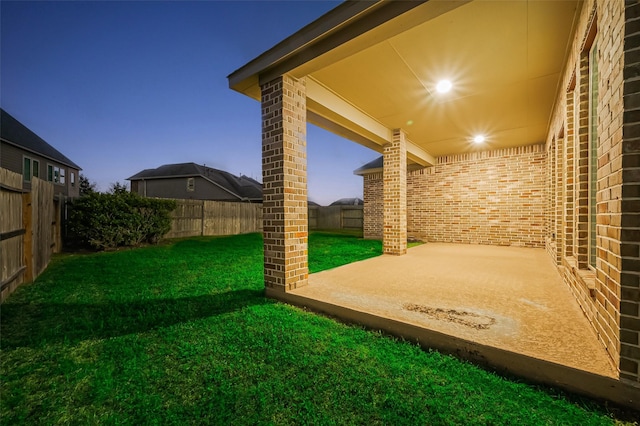 yard at dusk featuring a patio and a fenced backyard
