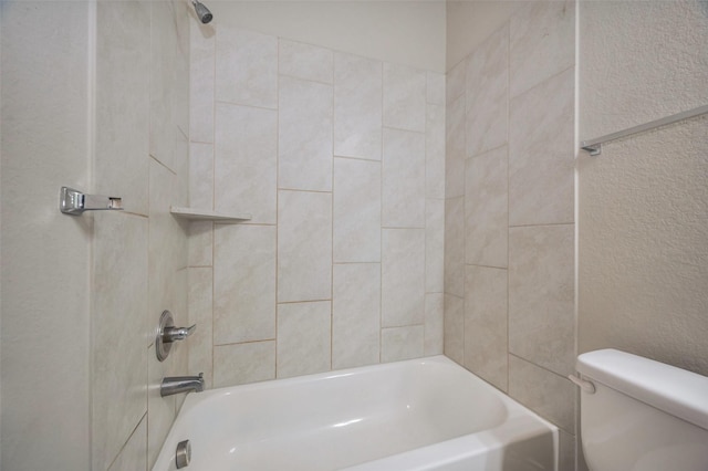 full bathroom with tub / shower combination, toilet, and a textured wall