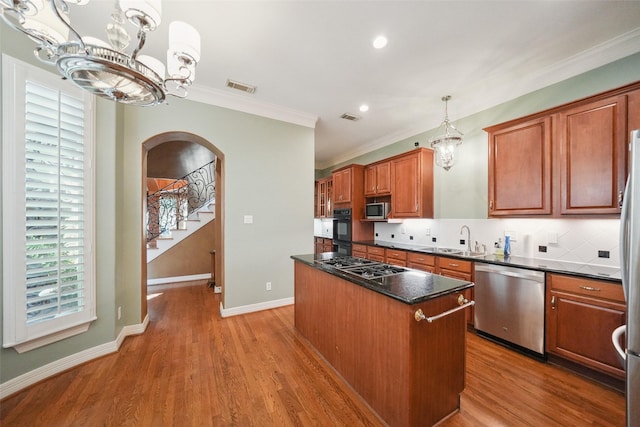 2112 Mcduffie St, Houston, TX 77019 - kitchen with appliances with stainless steel finishes, a chandelier, a center island, a sink, and arched walkways