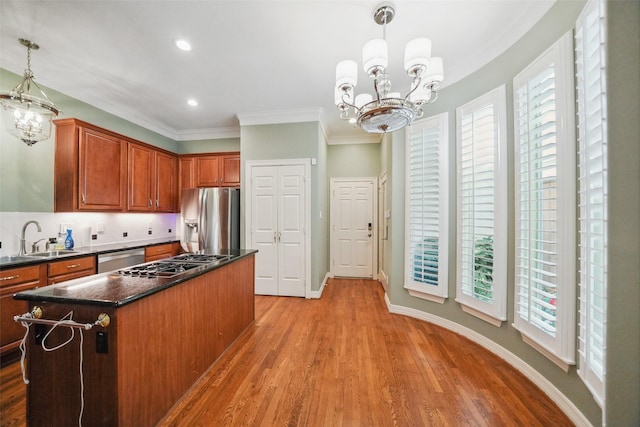 2112 Mcduffie St, Houston, TX 77019 - kitchen featuring appliances with stainless steel finishes, a sink, a chandelier, dark countertops, and ornamental molding