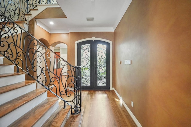2112 Mcduffie St, Houston, TX 77019 - foyer entrance with arched walkways, french doors, wood finished floors, stairway, and ornamental molding