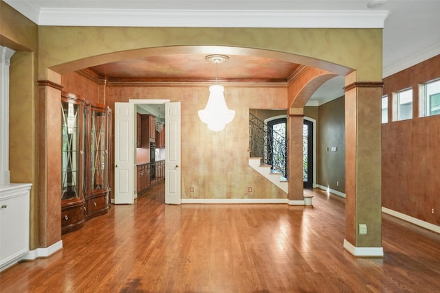 2112 Mcduffie St, Houston, TX 77019 - unfurnished dining area featuring wood finished floors, arched walkways, stairway, ornamental molding, and baseboards