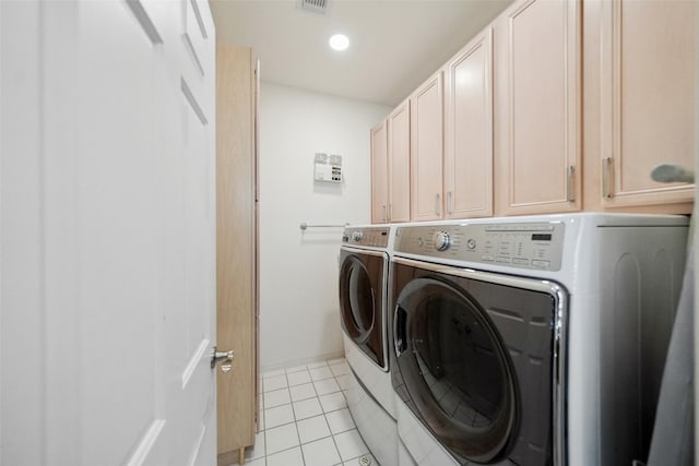2112 Mcduffie St, Houston, TX 77019 - clothes washing area with washer and dryer, cabinet space, light tile patterned flooring, and baseboards