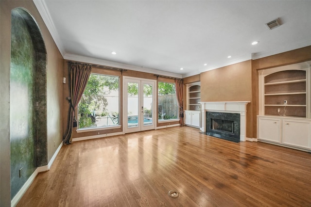 2112 Mcduffie St, Houston, TX 77019 - unfurnished living room with crown molding, built in features, baseboards, a fireplace, and wood finished floors