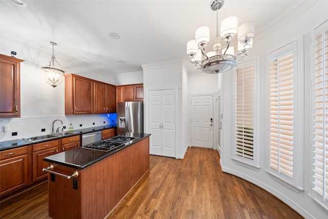 2112 Mcduffie St, Houston, TX 77019 - kitchen featuring a chandelier, stainless steel appliances, a center island, decorative backsplash, and crown molding
