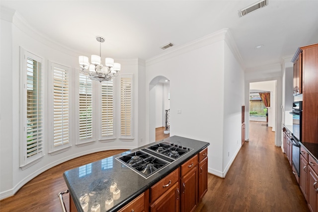 2112 Mcduffie St, Houston, TX 77019 - kitchen featuring stovetop with downdraft, arched walkways, a chandelier, oven, and dark wood-style flooring