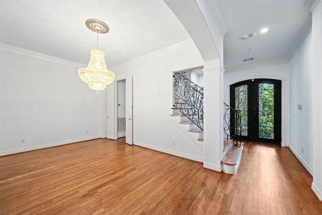 2112 Mcduffie St, Houston, TX 77019 - entryway with wood finished floors, crown molding, stairs, a chandelier, and arched walkways