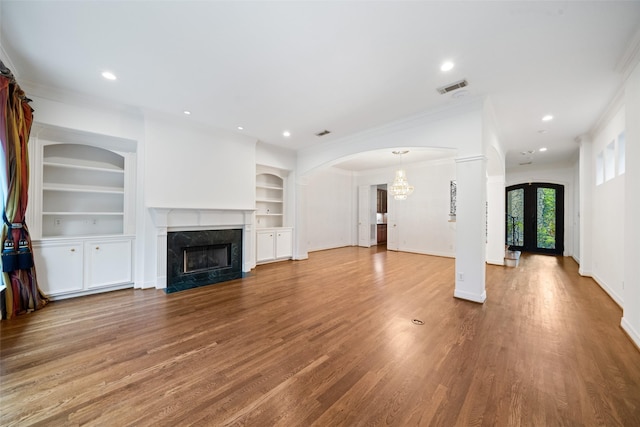 2112 Mcduffie St, Houston, TX 77019 - unfurnished living room with crown molding, a premium fireplace, built in shelves, wood finished floors, and recessed lighting