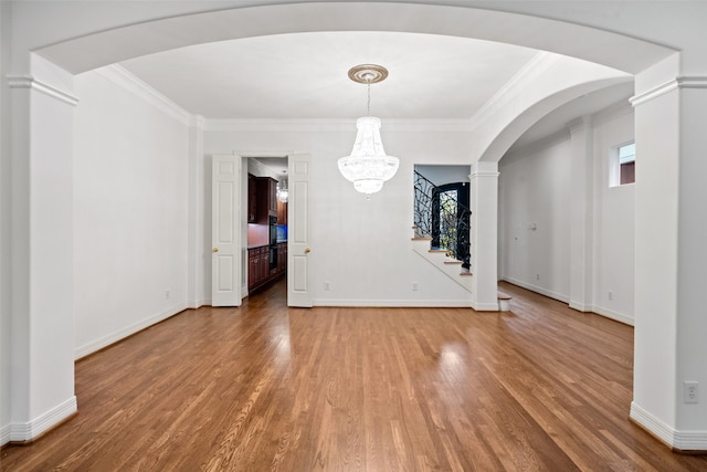 2112 Mcduffie St, Houston, TX 77019 - unfurnished dining area with light wood finished floors, crown molding, stairway, arched walkways, and a chandelier