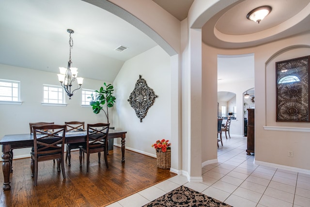 1415 Nacogdoches Valley Dr, League City, TX 77573 - dining space featuring visible vents, arched walkways, an inviting chandelier, light tile patterned floors, and baseboards