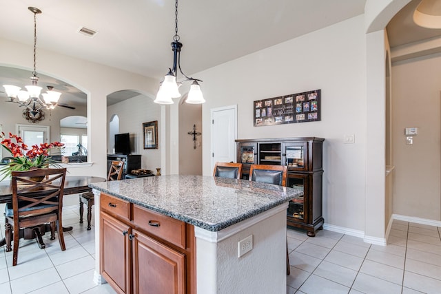 1415 Nacogdoches Valley Dr, League City, TX 77573 - kitchen with light tile patterned floors, arched walkways, a kitchen island, and an inviting chandelier