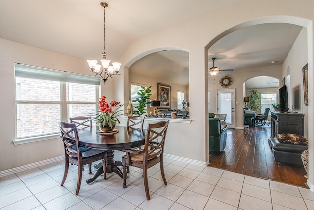 1415 Nacogdoches Valley Dr, League City, TX 77573 - dining area with baseboards, vaulted ceiling, ceiling fan with notable chandelier, arched walkways, and light tile patterned flooring