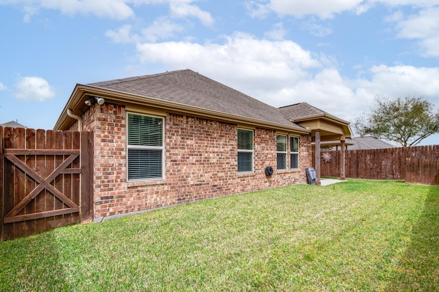 1415 Nacogdoches Valley Dr, League City, TX 77573 - back of property featuring brick siding, roof with shingles, a yard, and fence
