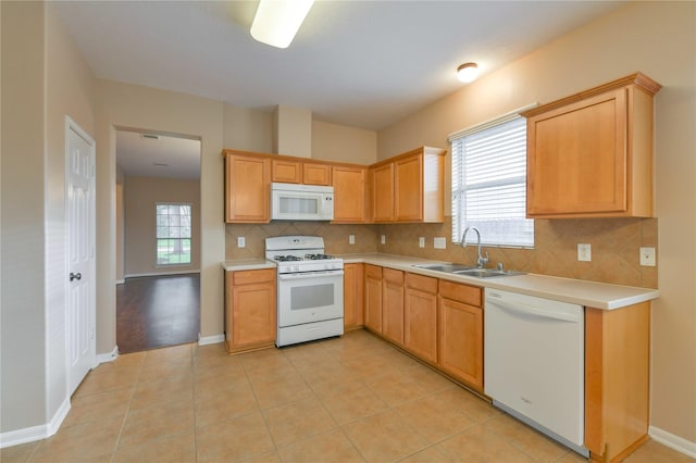 18015 Secret Branch Ln, Cypress, TX 77433 - kitchen with white appliances, a sink, backsplash, light countertops, and baseboards