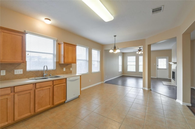 18015 Secret Branch Ln, Cypress, TX 77433 - kitchen featuring a sink, white dishwasher, light countertops, tasteful backsplash, and light tile patterned floors