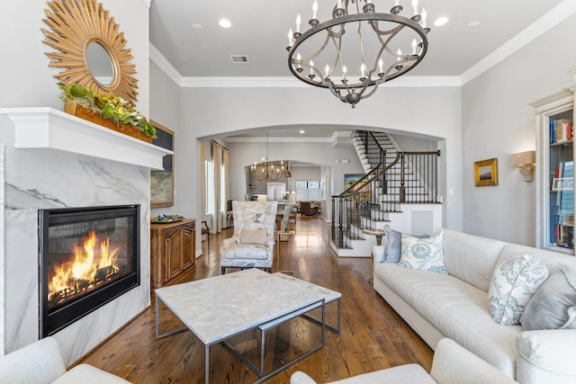 308 W Saulnier St, Houston, TX 77019 - living area with dark wood-style flooring, visible vents, stairway, arched walkways, and an inviting chandelier