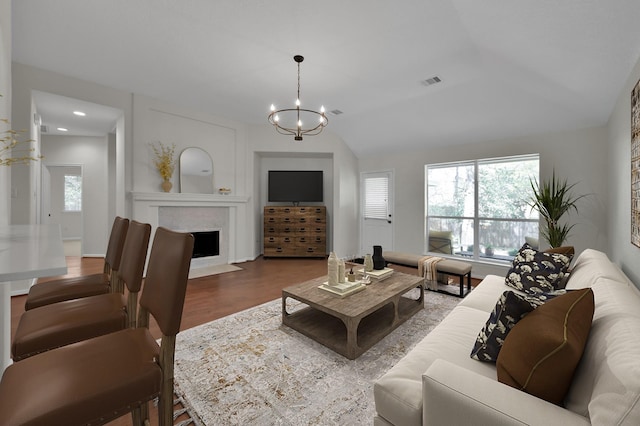 82 S Regan Mead Cir, Montgomery, TX 77382 - living room with a chandelier, a fireplace with flush hearth, wood finished floors, vaulted ceiling, and recessed lighting