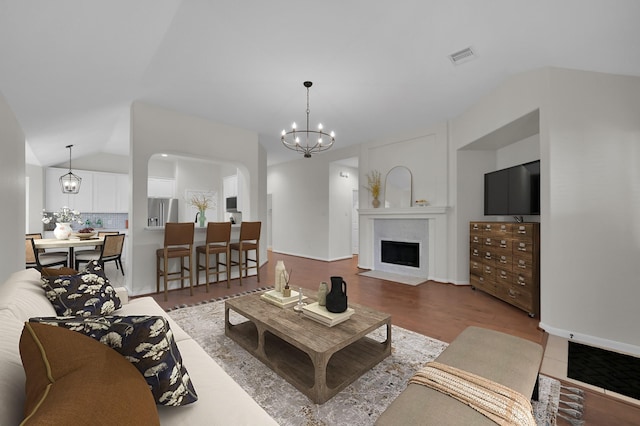82 S Regan Mead Cir, Montgomery, TX 77382 - living area featuring a chandelier, lofted ceiling, a fireplace with flush hearth, and wood finished floors