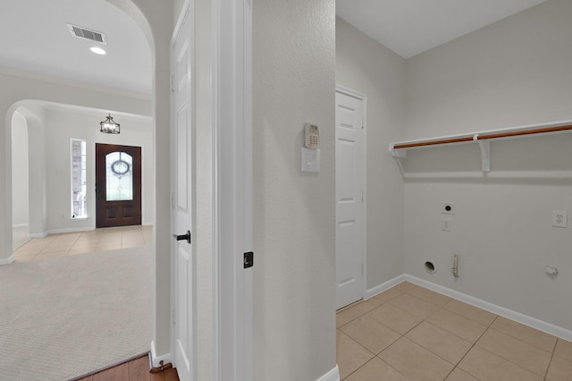 82 S Regan Mead Cir, Montgomery, TX 77382 - laundry area featuring hookup for a gas dryer, arched walkways, electric dryer hookup, light tile patterned floors, and baseboards
