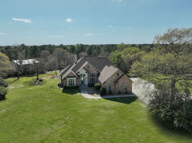8536 Prince William Ct, Montgomery, TX 77316 - view of front facade featuring brick siding, a front lawn, a chimney, and a wooded view