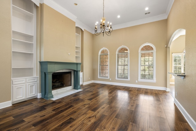 8536 Prince William Ct, Montgomery, TX 77316 - unfurnished living room featuring a tiled fireplace, a chandelier, built in features, baseboards, and dark wood-type flooring